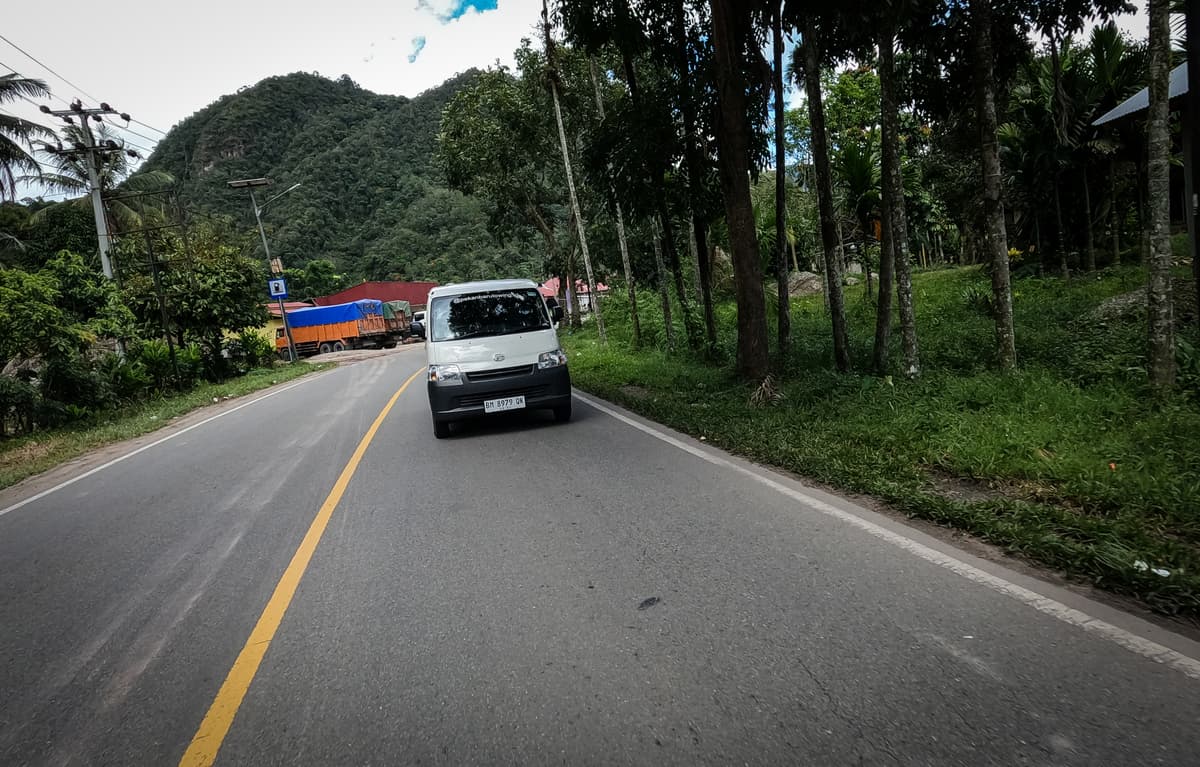 Suasana camping santai di perbukitan bersama, dikelilingi tenda, motor, dan cahaya yang hangat.
